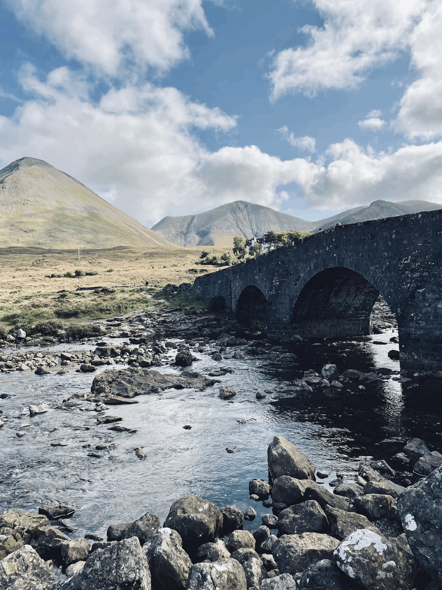 Eine alte Steinbrücke unter der das Wasser durch die Bögen hindurchfließt.